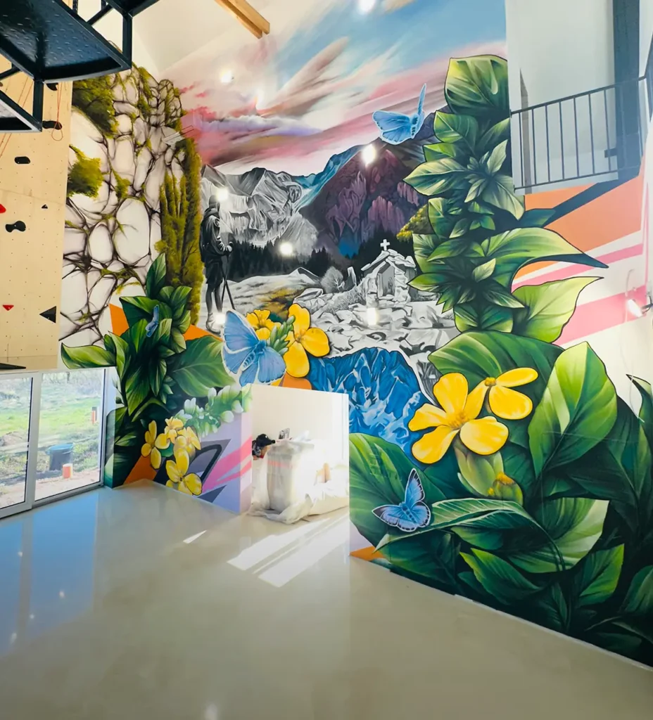 Photography of a mural image on a wall in interior. The image depicts floral motives and mountains with perspective